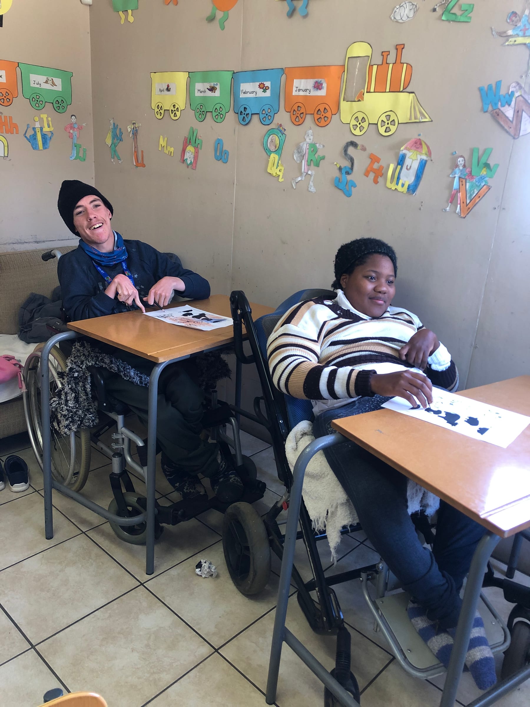 Two young adults participating in a learning activity at a South African care center